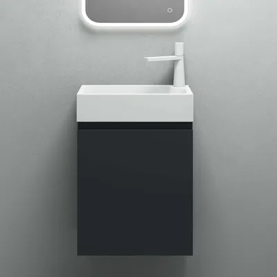 A modern bathroom vanity with a white sink and a dark gray cabinet against a gray wall.