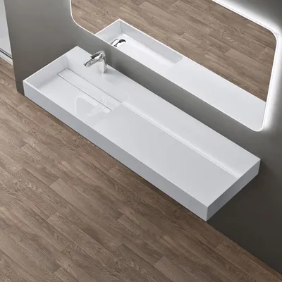 A modern white washbasin with a chrome faucet is shown in a bathroom setting with wooden flooring and a gray wall.