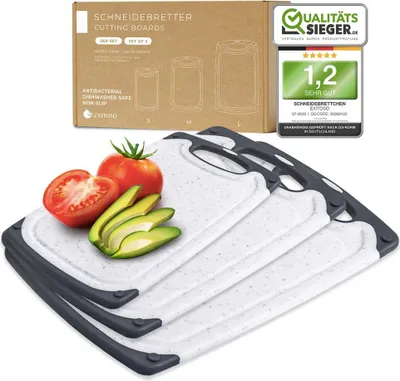 A set of three cutting boards with a tomato and avocado on top, with packaging and a quality seal in the background.