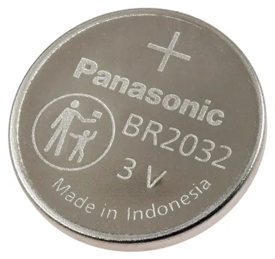 A close-up, top-down view of a single silver coin-cell battery.