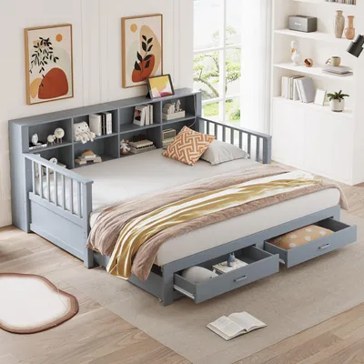A bedroom scene featuring a gray daybed with a bookshelf headboard and storage drawers. The bed is made with beige and brown bedding and pillows. There are two framed pictures on the wall above the headboard.