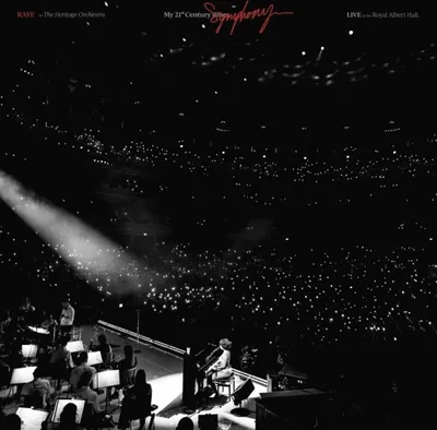 A live orchestral performance with a pianist in the foreground and a large audience in the background holding up lights.