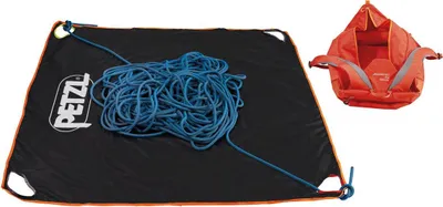 darauf liegt ein blaues Kletterseil. Daneben ein roter Seilsack mit grauen Tragegurten.