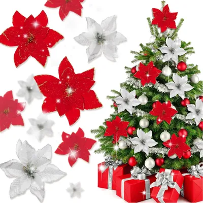 A Christmas tree decorated with red and white poinsettias and ornaments, with additional poinsettias and wrapped gifts in the foreground.