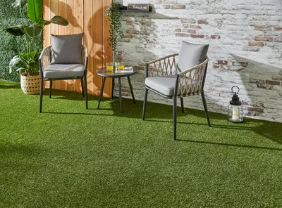 Grüner Kunstrasenteppich ausgelegt auf einer Terrasse.