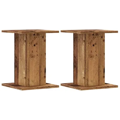 Two wooden speaker stands against a white background.