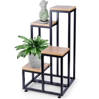 A multi-tiered plant stand with a plant and a statue on it, against a white background.