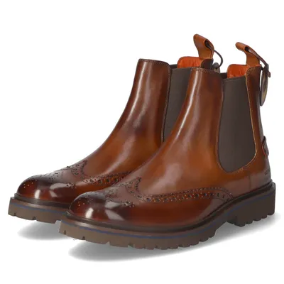 A pair of brown leather Chelsea boots with brogue detailing.