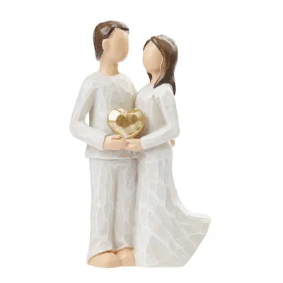 A figurine of a couple holding a heart.