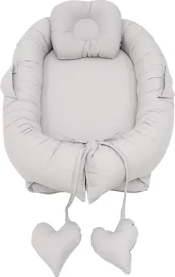 A baby nest with a headrest and two heart-shaped pillows attached by strings.