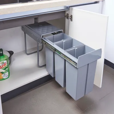 A pull-out trash bin system with three compartments installed under a kitchen counter.