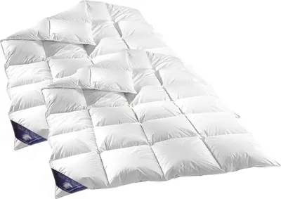 A white down comforter is laid out on a white background.