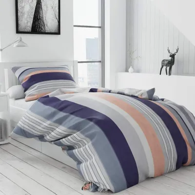 A bedroom scene with a bed dressed in striped bedding.