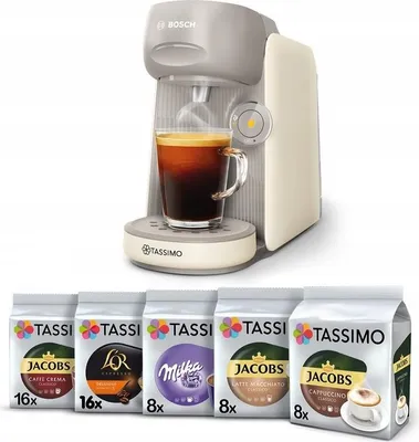 A coffee machine with a cup of coffee and several packs of coffee capsules.