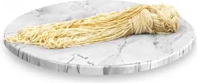A bundle of dried pasta or noodles on a marble-patterned plate.