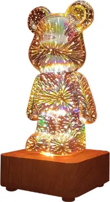 A clear product shot of a teddy bear-shaped night light on a wooden base.