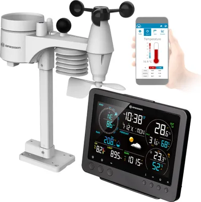 A weather station with a display and a smartphone showing weather data.