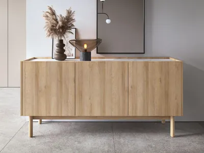 A wooden sideboard with decorative items on top, placed against a light gray wall.