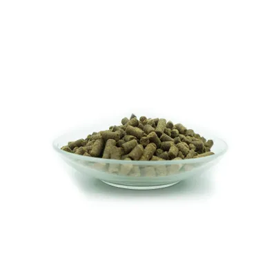 A clear studio shot of a glass bowl filled with brown pellets, likely pet food, against a white background.