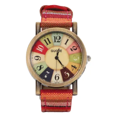 A close-up studio shot of a women's wristwatch with a colorful dial and a striped fabric strap.