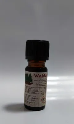 Kleine braune Flasche mit einem schwarzen Verschluss. Auf dem Etikett steht "Waldduft".