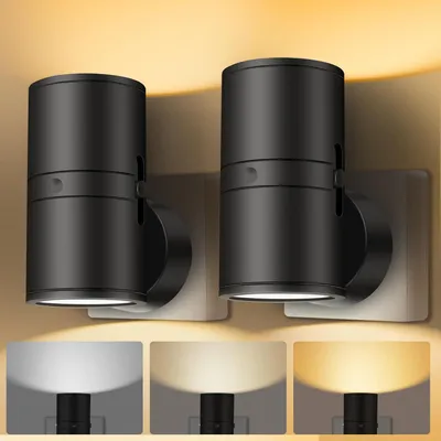 Two black LED plug-in night lights are shown mounted on a wall, with a warm yellow light cast upwards. Below the main image, three smaller panels display the lights emitting different shades of light: white, warm white, and yellow.