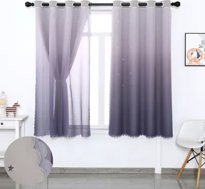 A pair of ombre purple curtains with a star pattern hanging in front of a window, with a small table and chair visible to the side.