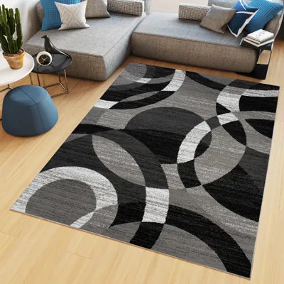 A modern living room with a sectional sofa, a rug, and a blue ottoman.