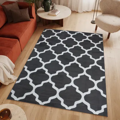 A living room scene with a rug, sofa, coffee table, and chair.