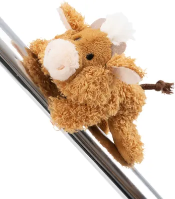 A plush toy cow is attached to a metallic pole.