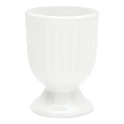 A white ceramic egg cup with vertical ridges and a pedestal base, isolated on a white background.