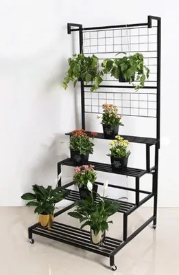 A black metal plant stand with multiple tiers, holding various potted plants.