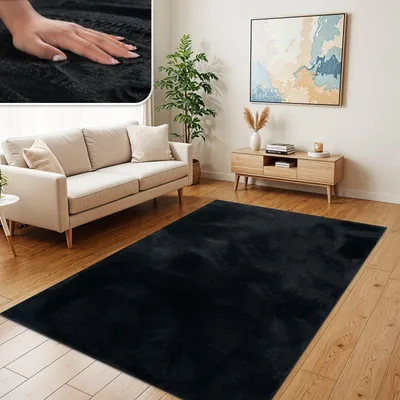 A living room scene with a sofa, rug, and media console.