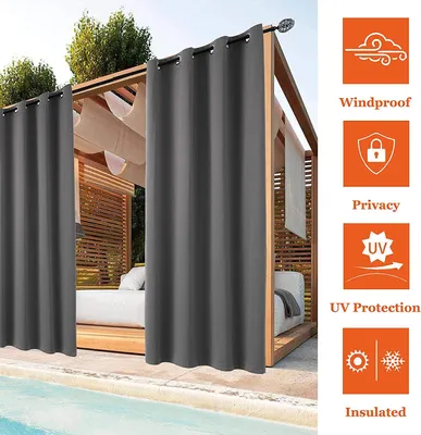 Outdoor curtains hanging around a cabana by a pool.