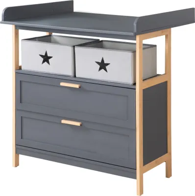 A gray changing table with two fabric storage boxes with stars on them and two drawers, set against a white background.