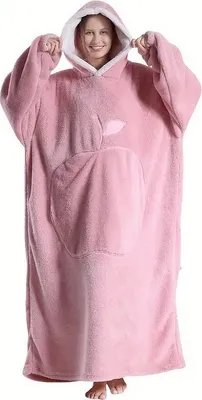 A woman wearing a pink oversized hoodie blanket.