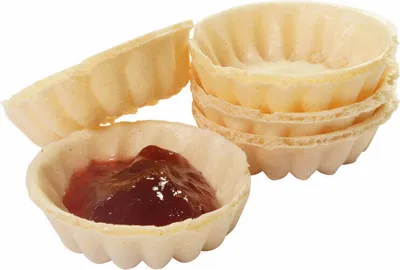 A close-up shot of several empty waffle cups and one filled with jam.