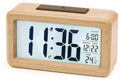 A digital alarm clock with a wooden casing is displayed against a white background.