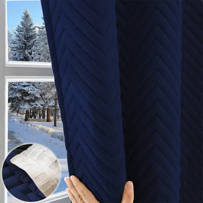 A hand is shown holding a navy blue quilted curtain, with a winter scene visible through a window in the background. A small inset image shows a close-up of the fabric texture.
