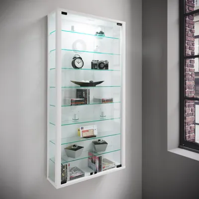 A white wall-mounted display cabinet with glass shelves and doors, showcasing various items.