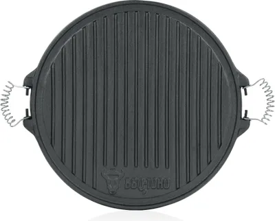 A top-down view of a round, black cast iron grill plate with ridged surface and two spring-like handles on the sides. A logo is visible at the bottom center.