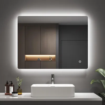 A modern bathroom vanity with a sink and a large LED mirror.