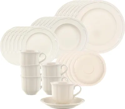 A collection of white ceramic plates and cups arranged in stacks.
