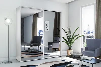 A modern living room with a large mirrored wardrobe, two armchairs, a coffee table, and a floor lamp.