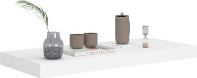 A white floating shelf with decorative items.