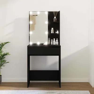 A black vanity table with a lighted mirror and shelves, set against a white wall.