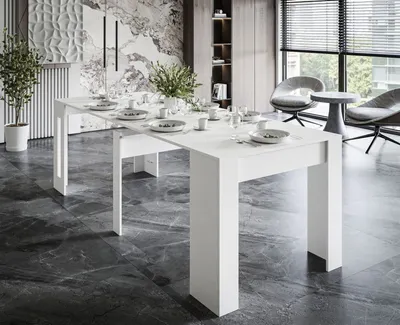A modern dining room with a white extendable table set for a meal, featuring chairs and blinds in the background.