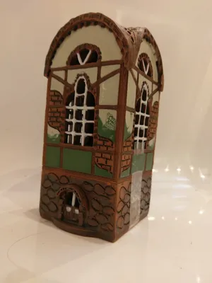 Das Keramikhaus ist in braunen, weißen und gelb-grünen Tönen gehalten, mit einem Fachwerk-Design.