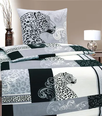 A bed with leopard-print bedding and a pillow.