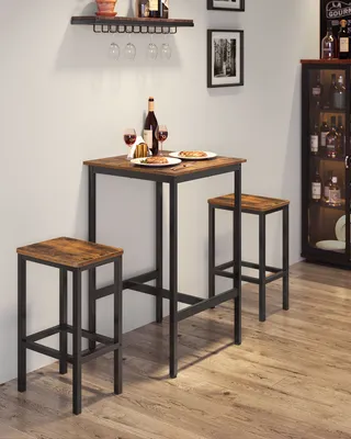 A bar table set with two stools is shown in a room with a wine cabinet in the background.